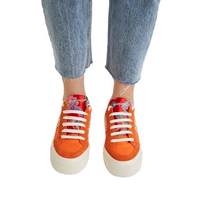 Orange designer sneakers with white laces and graphic details, worn with cropped jeans on GUOCALI