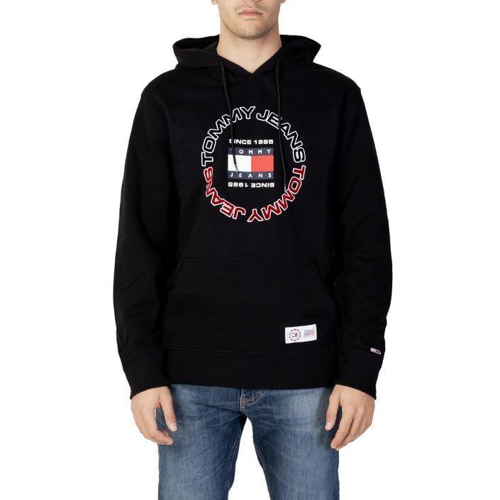 Man wearing black Tommy Jeans hoodie with logo, part of men's designer fashion collection at GUOCALI