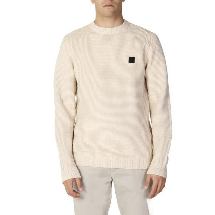 Man wearing a cream ribbed sweater with black logo patch, GUOCALI Paris men's clothing