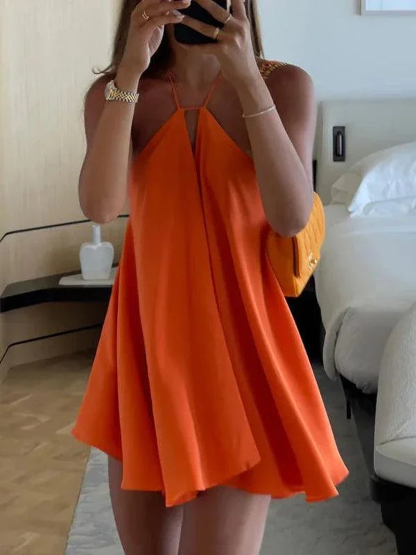Woman wearing a bright orange halter mini dress in a modern bedroom, GUOCALI luxury fashion