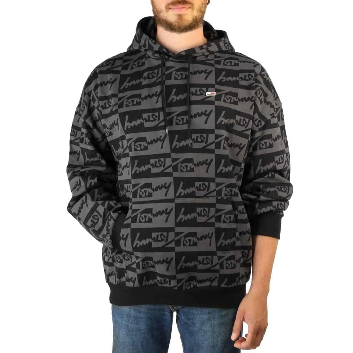 Man wearing a grey and black printed pullover hoodie with jeans fashion image