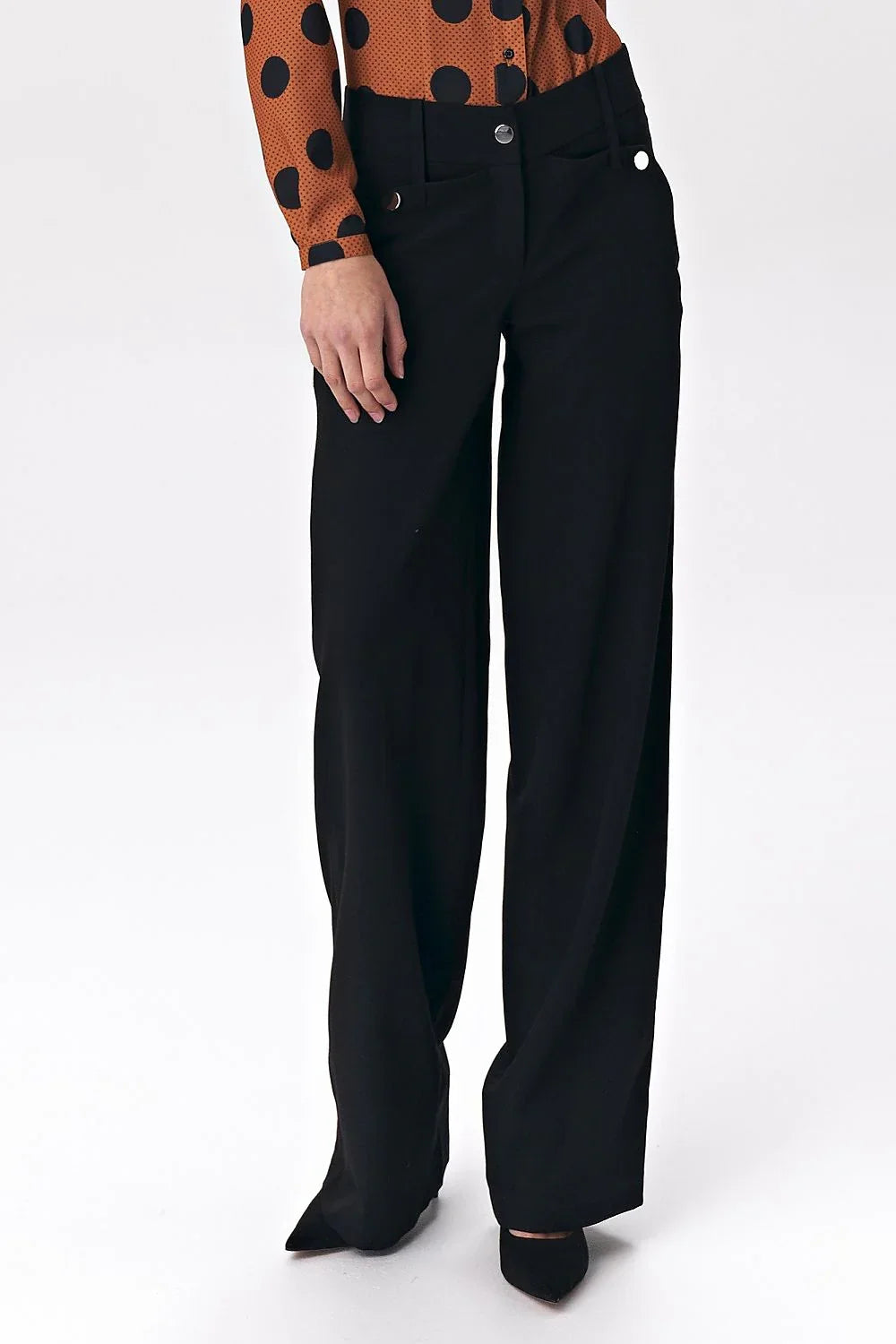Black high-rise wide-leg trousers with button detail, worn with a polka dot blouse fashion image