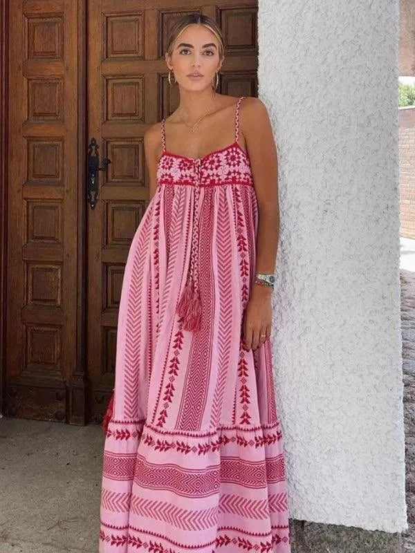 Woman in a pink and red patterned sleeveless maxi sundress with tassel ties fashion image