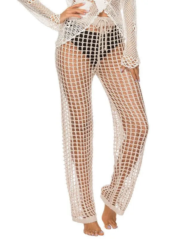 White open-knit crochet beach pants worn over a black bikini bottom fashion image